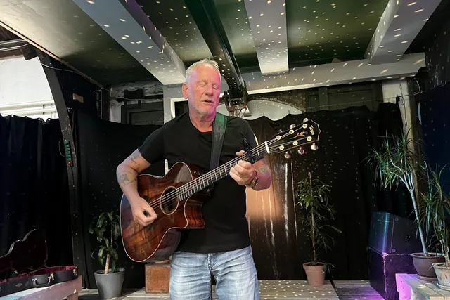 Lars Bo Bendixen står og spiller guitar med lukkede øjne